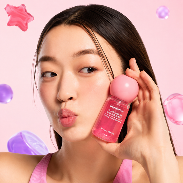Femme à la peau lumineuse tenant le Biodance Collagen Peptide Jelly Serum Mist 50 ml, une brume hydratante au collagène et peptides pour une peau éclatante.