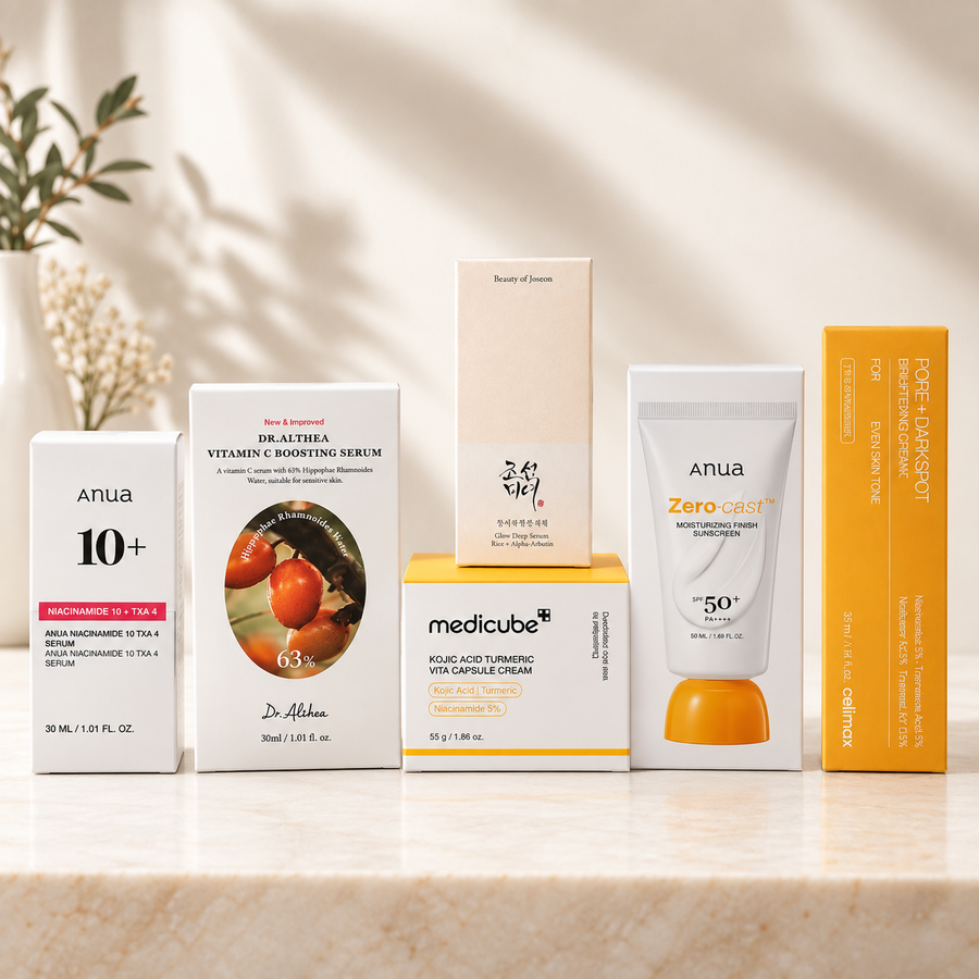 Routine anti-taches K-Beauty Glass Skin Hub composée de six soins : sérum Anua Niacinamide 10% + TXA 4%, sérum Vitamin C Boosting Dr.Althea, sérum Glow Deep Beauty of Joseon à l’alpha-arbutine, crème Medicube Kojic Acid Turmeric, crème Celimax Pore + Dark Spot Brightening et protection solaire Anua Zero-Cast SPF50+. Produits présentés sur un fond beige lumineux et minimaliste.